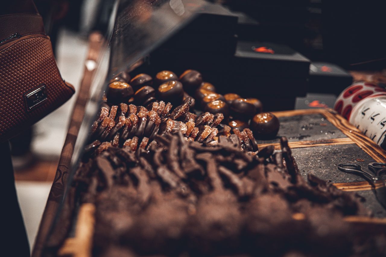 Close-up of a variety of artisanal chocolates on display in a dark and moody setting.