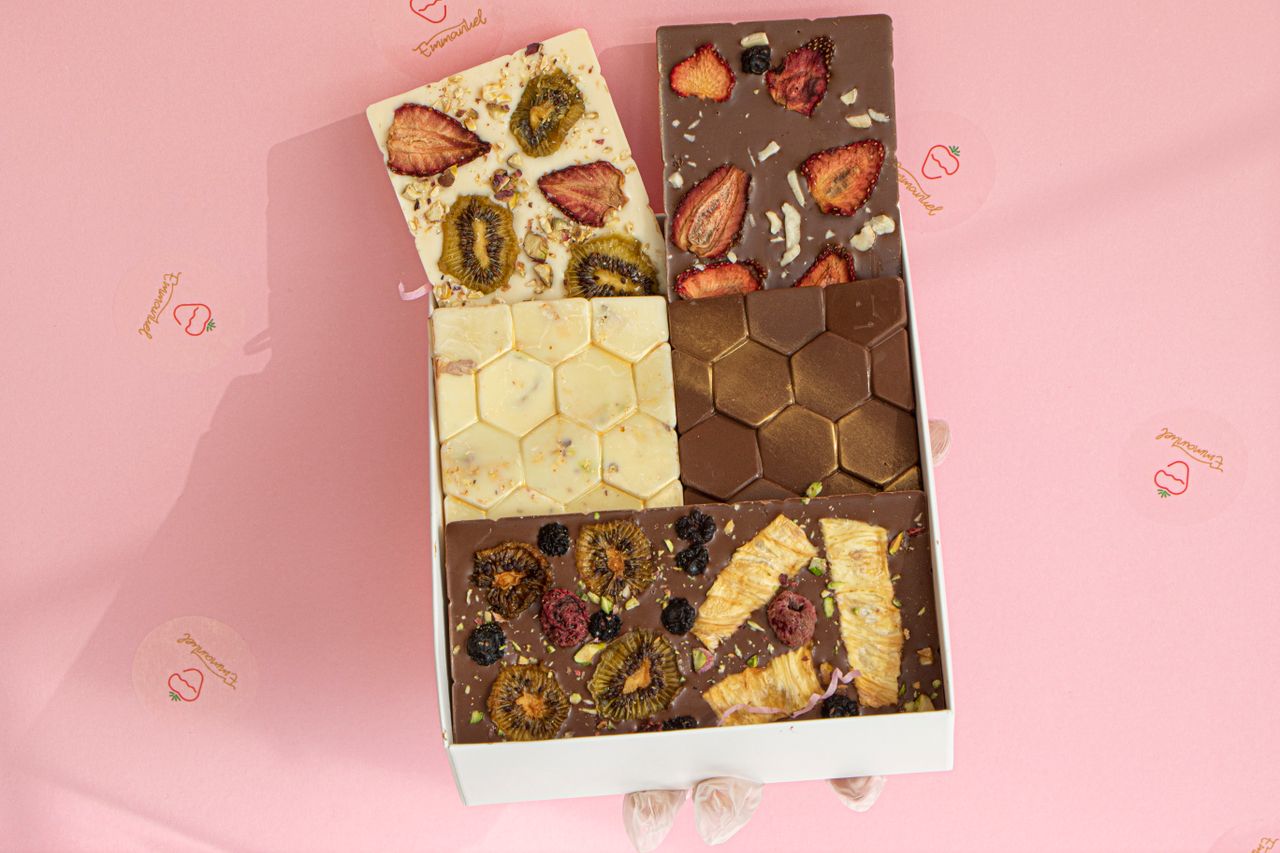Delicious assortment of gourmet chocolates topped with dried fruits in a box.
